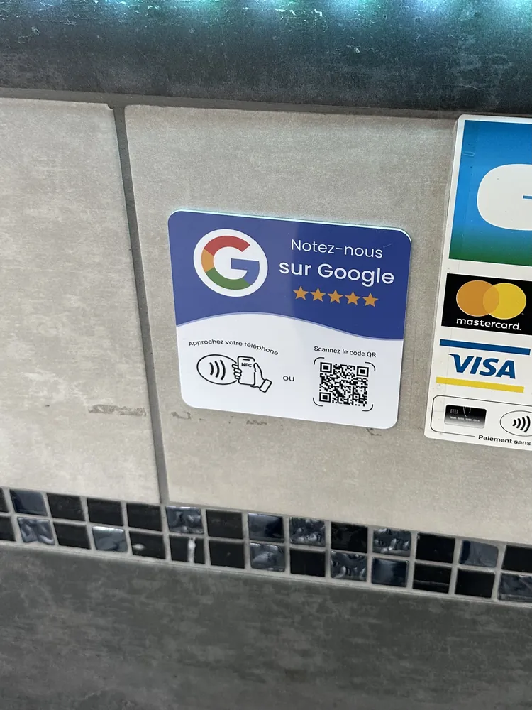 Plaque Google posée au mur, à côté du terminal de paiement